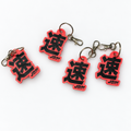 Red and black 3D printed JDM keyrings with metal split rings and lobster clasps on a white background